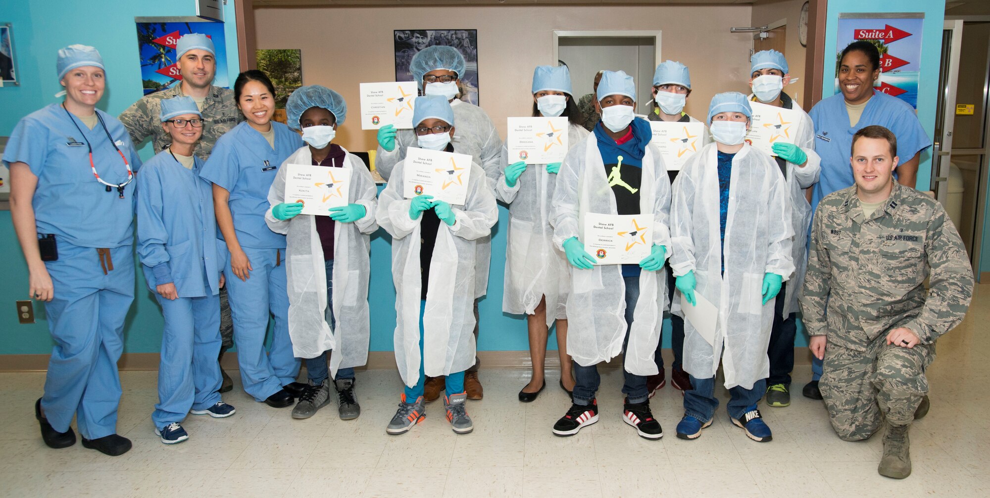 U.S. Airmen assigned to the 20th Dental Squadron pose for a graduation photo with Crosswell Home for Children residents at Shaw Air Force Base, S.C., March 8, 2018.