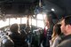 Airman talking to civilian guests in the cockpit of a C-130 Hercules aircraft during tour.