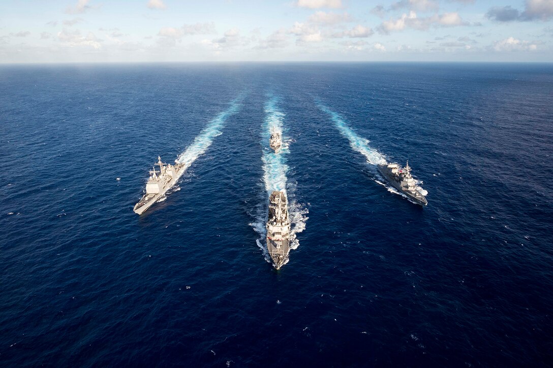 The guided missile destroyer USS Mustin leads a four-ship formation