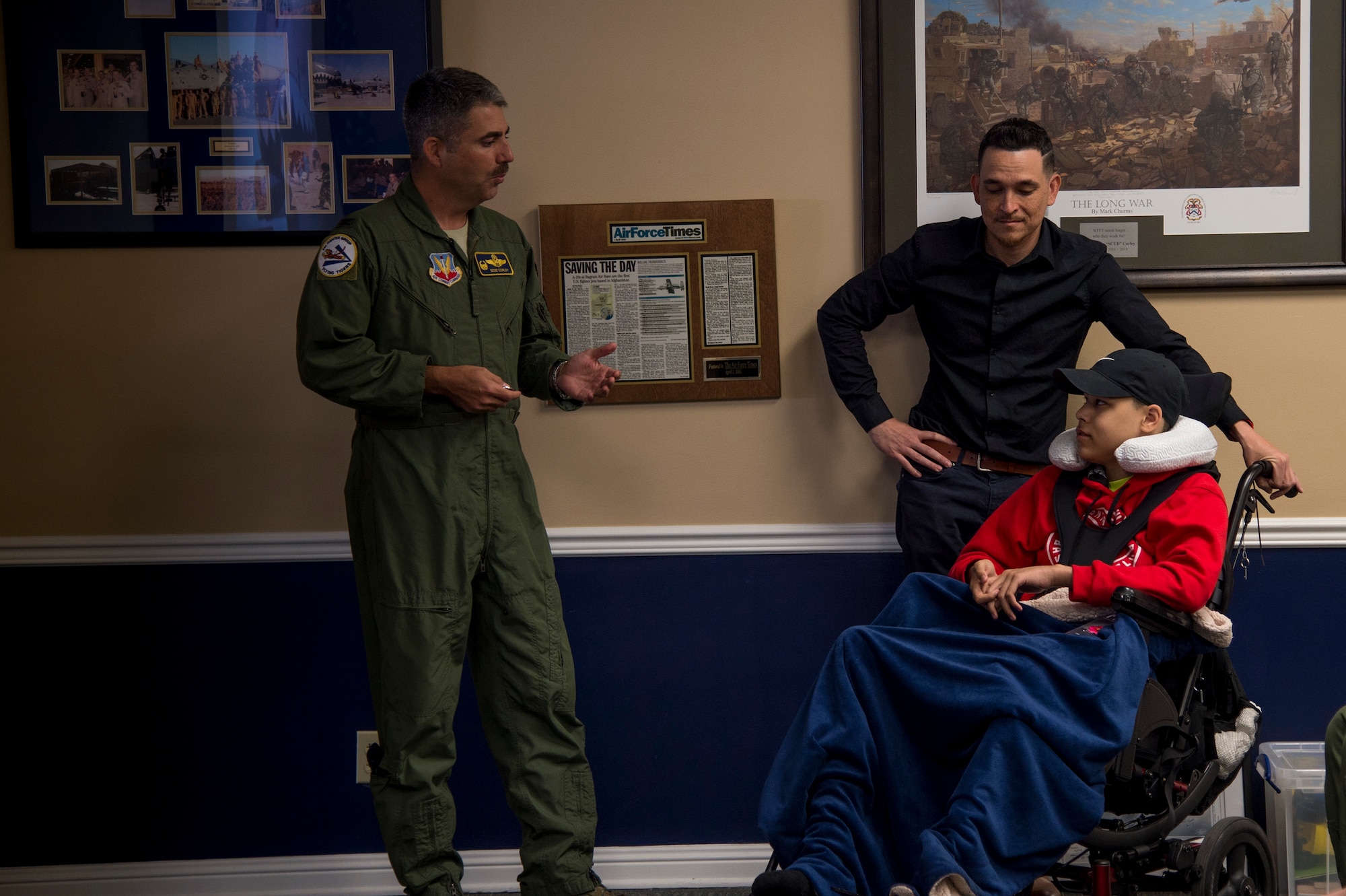 Col. Michael Curely, 23d Figther Group commander, presents 15-year-old Jarod Story with a 23d Wing coin, at Moody Air Force Base, Ga., March 14. Pilots from the 23d Fighter Group made Storey, who is terminally ill with Osteosarcoma, a rare form of bone cancer, an honorary A-10C Thunderbolt II pilot for a day. (U.S. Air Force photo by Andrea Jenkins)