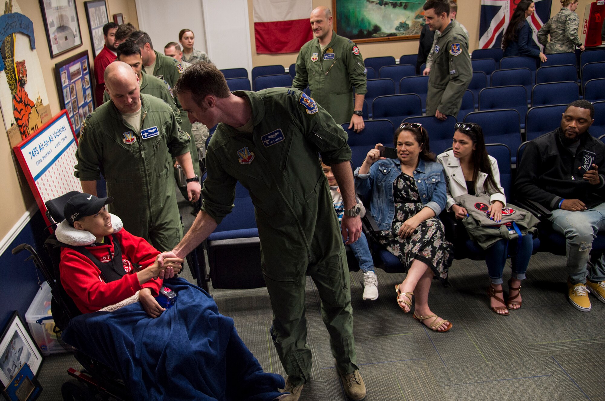 Capt. Eric Laprade, 74th Fighter Squadron A-10C Thunderbolt II pilot, shake hands with 15-year-old Jarod Story, March 14, 2018, at Moody Air Force Base, Ga. Pilots from the 23d Fighter Group made Storey, who is terminally ill with Osteosarcoma, a rare form of bone cancer, an honorary A-10 pilot for a day. (U.S. Air Force photo by Andrea Jenkins)