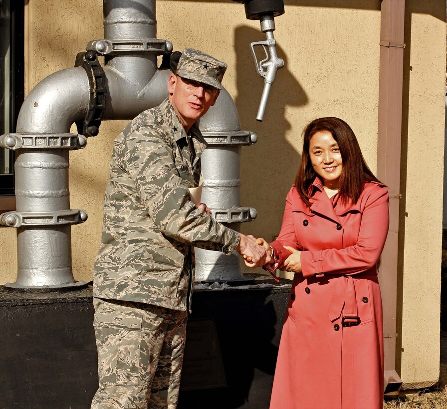 Air Force Brig. Gen. Martin Chapin hands a coin to Ni Na Yi.