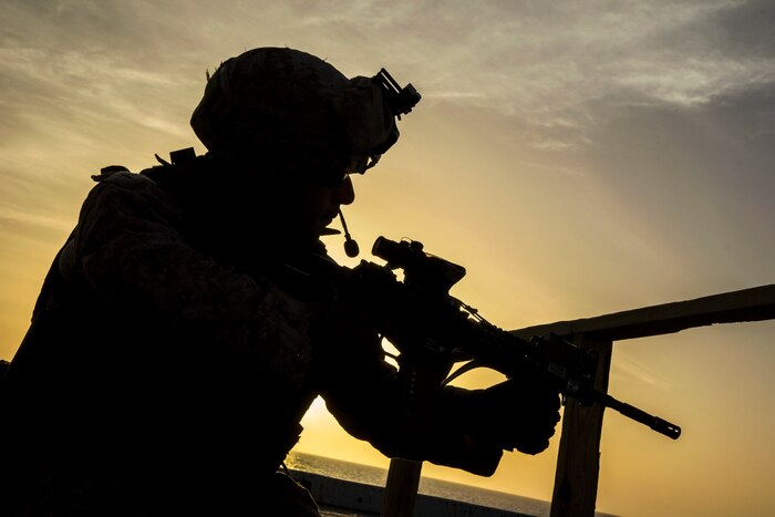 A Marine fires a weapon during a routine deck shoot at sea.
