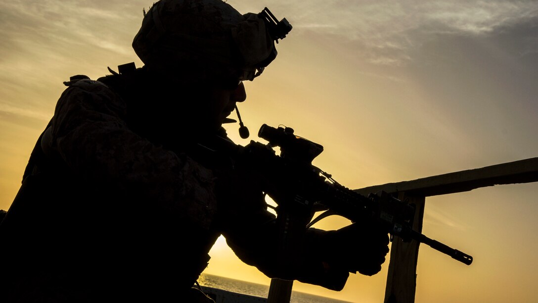 A Marine fires a weapon during a routine deck shoot at sea.