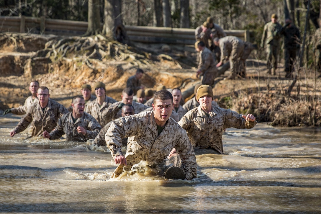 Marines run into water as they participate in training to evaluate them as potential officers.