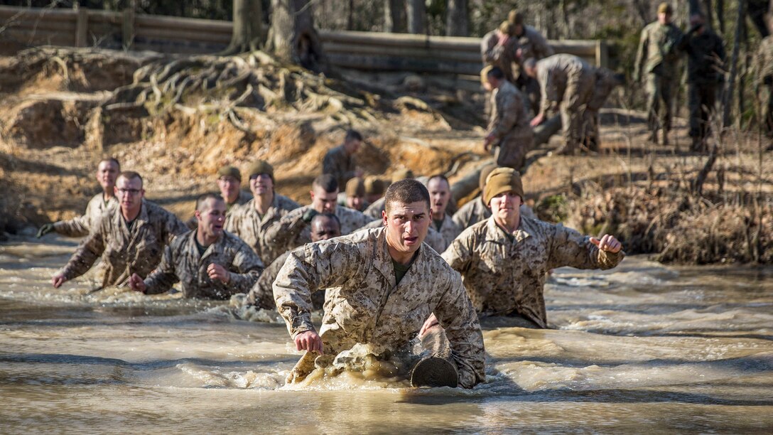 Marines run into water as they participate in training to evaluate them as potential officers.