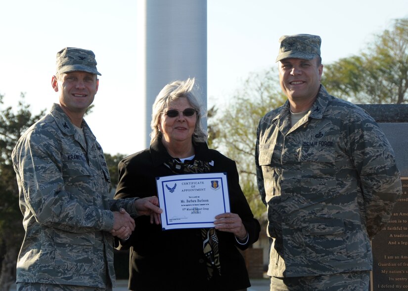 U.S. Air Force Col. Anthony Krawietz, wing commander for 97th Air Mobility Wing, and Col. Michael Griener, commander for 97th Mission Support Group, induct Barbara Burleson, a former honorary commander for the 97th Civil Engineer Squadron, as the 97th MSG Honorary Commander, Nov. 29, 2012, at Altus Air Force Base, Okla.