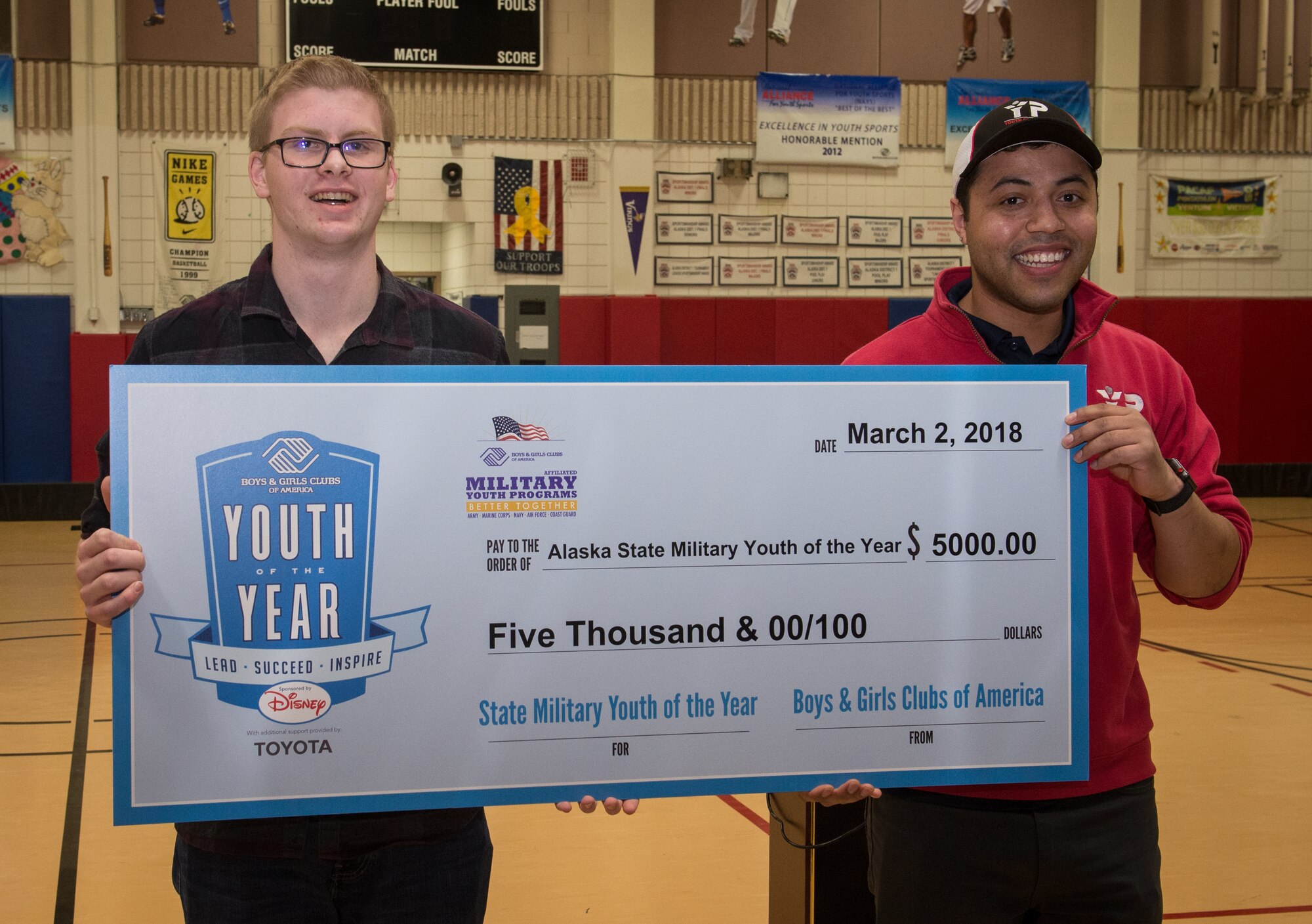 Jon Peterson, left, is recognized as this year’s Boys and Girls Clubs of America Military Youth of the Year for the state of Alaska and awarded a $5,000 scholarship at Joint Base Elmendorf-Richardson, Alaska, March 7, 2018. The program is designed to promote service to club, community and family, academic success, strong moral character, life goals and poise and public speaking. Jon will now compete at the Pacific Air Forces regional level for a chance to win a $40,000 scholarship and an invitation to compete at the national level.