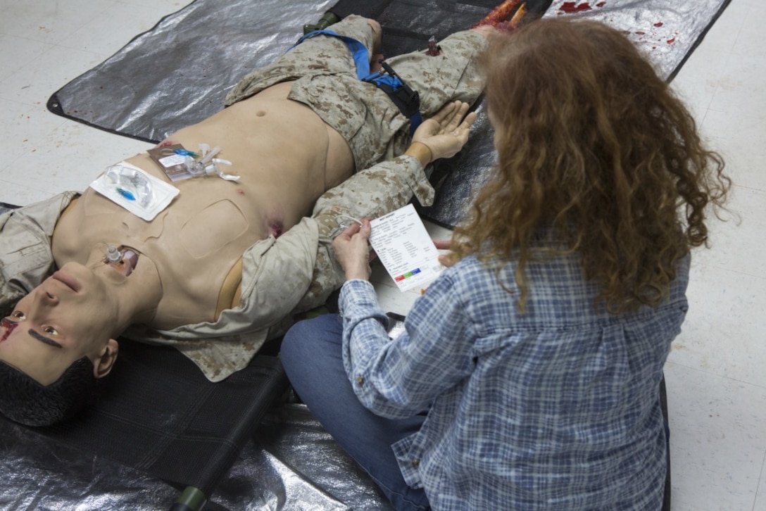 Associates from the Defense Advanced Research Projects Agency attend a brief about assisting a casualty during a visit at Camp Lejeune, N.C.