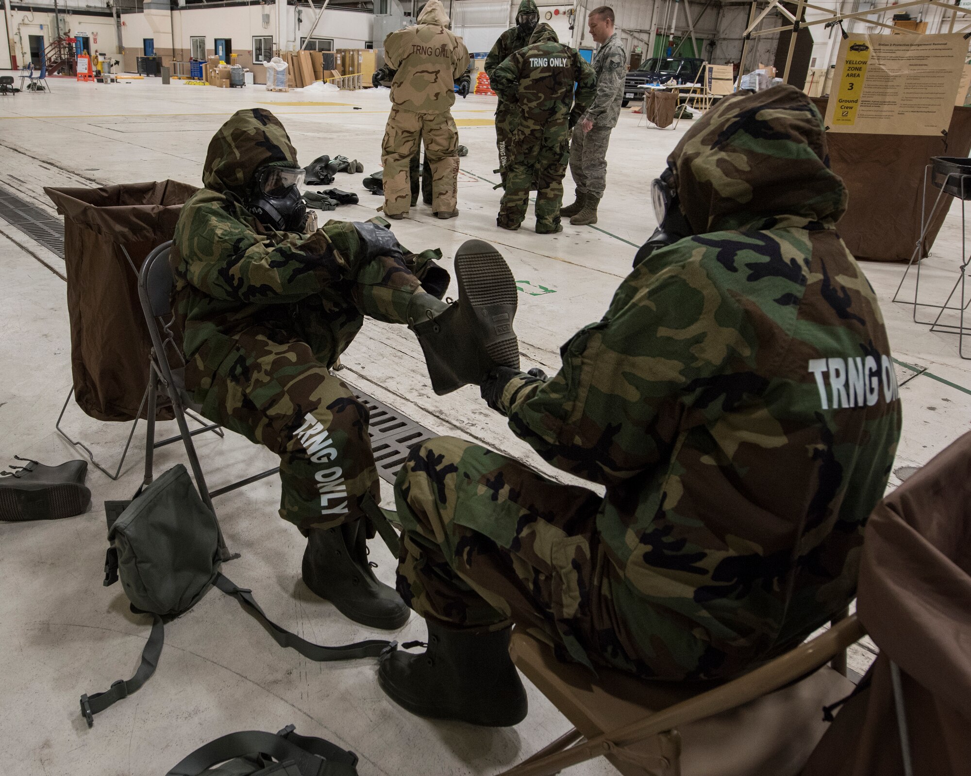 Airmen from the 141st Air Refueling Wing demonstrate proper removal of mission-oriented protective posture gear during Chemical, Biological, Radiological, Nuclear Defense training March 6, 2018 at Fairchild Air Force Base, Wash. The training was hosted by the 141st Civil Engineer Squadron as a refresher for Guardsmen to review proper procedures and wear of protective gear as well as decontamination procedures. (U.S. Air National Guard photo by Staff Sgt. Rose Lust)