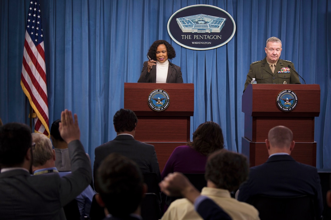 The chief Pentagon spokesperson and a Marine Corps general speak at a podium.