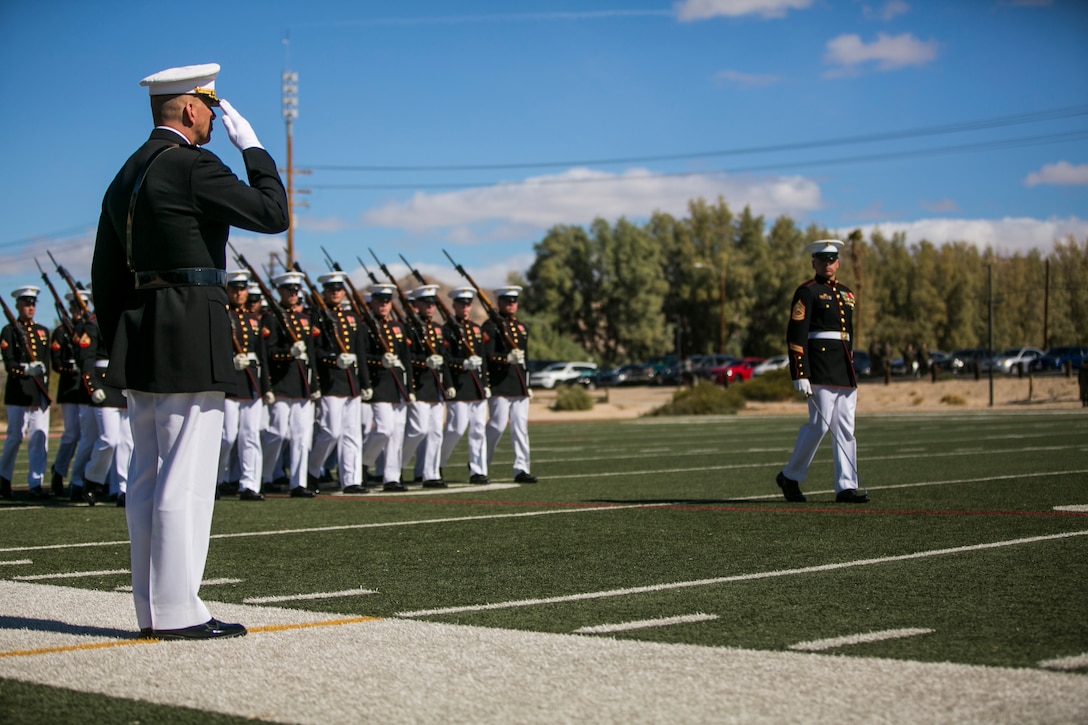 The U.S. Marine Corps Silent Drill Platoon, Battle Colors Detachment, Marine Barracks Washington, D.C., executes a pass and review in front of Maj. General William F. Mullen III, commanding general, Marine Corps Air Ground Combat Center, Twentynine Palms, Calif., during the Battle Colors Ceremony at Felix Field, March 14, 2018. The ceremony is held to honor Marine Corps traditions through the Drum Corps, the Silent Drill Platoon and the Battle Colors Detachment.