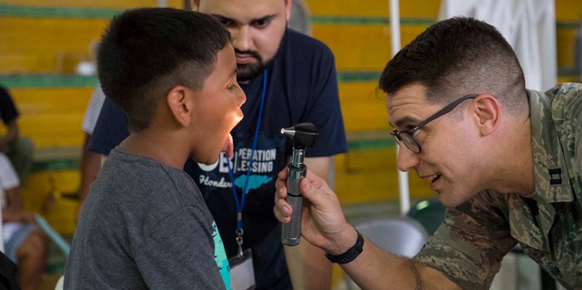 An Air Force doctor looks into a child's mouth during a physical exam in Honduras.