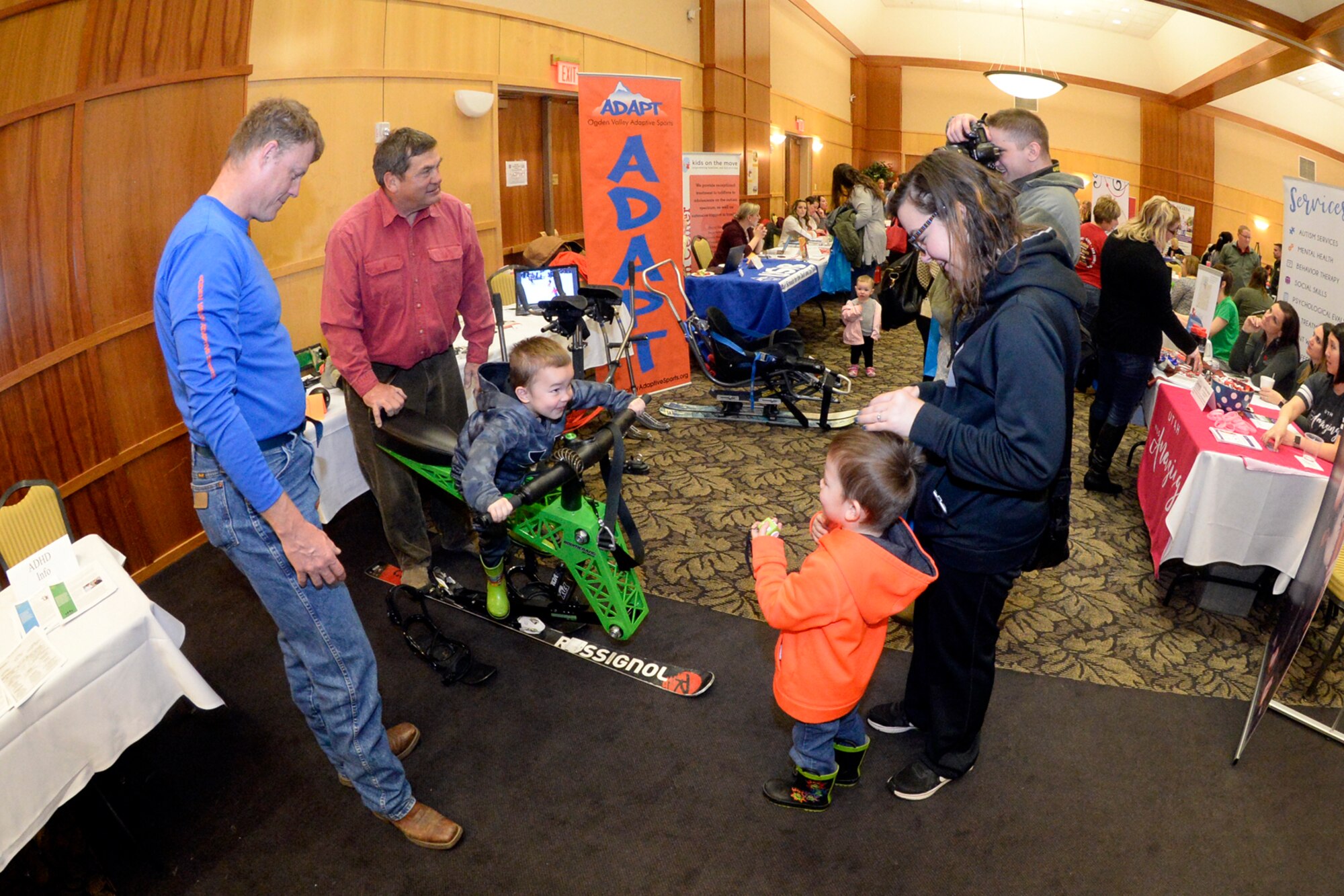 Don Hickman and Jim Bradley, ADAPT sports, demonstrate a ski chair to Sara Clippinger and children during the Special Needs Summit March 15, 2018, at Hill Air Force Base, Utah. The annual summit gives the base community a chance to research and learn about many special needs services and opportunities available in the area. (U.S. Air Force photo by Todd Cromar)