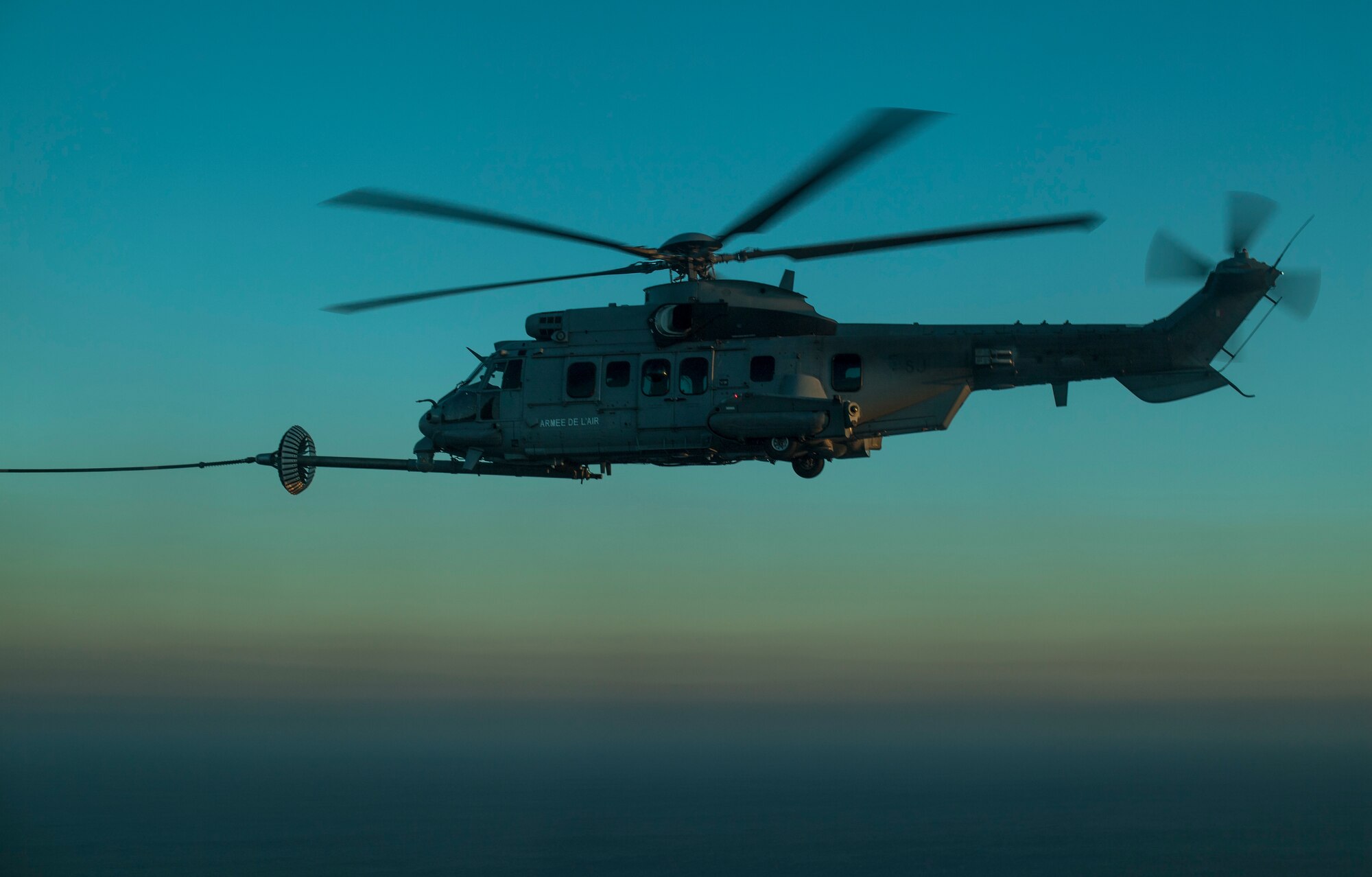 A NATO air force EC-725 Super Cougar receives fuel from a U.S. Air Force C-130 Hercules as part of Emerald Warrior over the Gulf of Mexico March 2, 2018. At Emerald Warrior, the largest joint and combined special operations exercise, U.S. Special Operations Command forces train to respond to various threats across the spectrum of conflict. (U.S. Air Force photo by Staff Sgt. Trevor T. McBride)