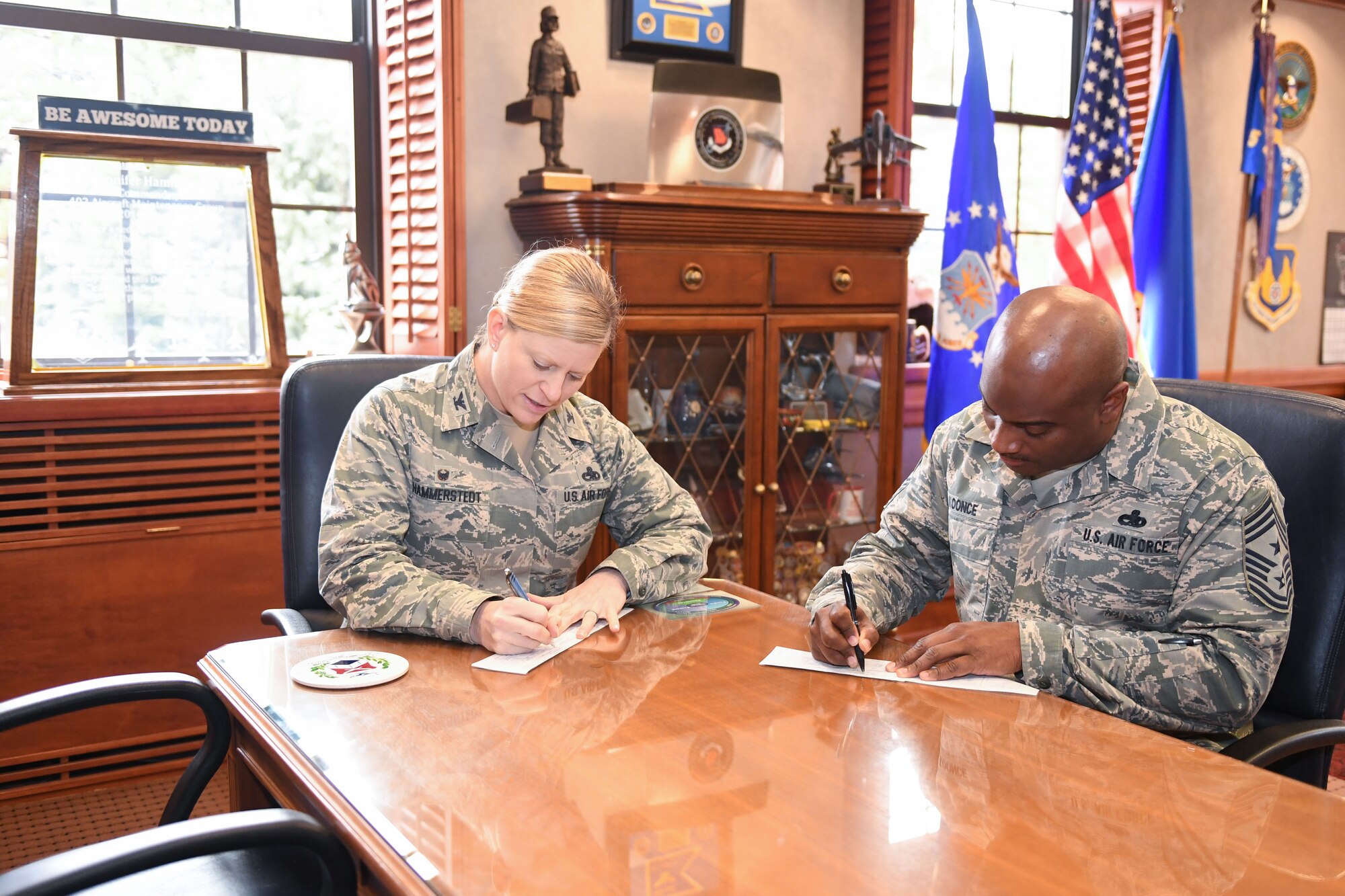 Col. Jennifer Hammerstedt, 75th Air Base Wing commander, and Chief Master Sgt. Rodney Koonce, 75th ABW command chief, sign Air Force Assistance Fund pledge forms to kick off the 2018 AFAF fundraising campaign. The Hill Air Force Base 2018 campaign will run March 26 through May 4. (U.S. Air Force photo by Cynthia Griggs)