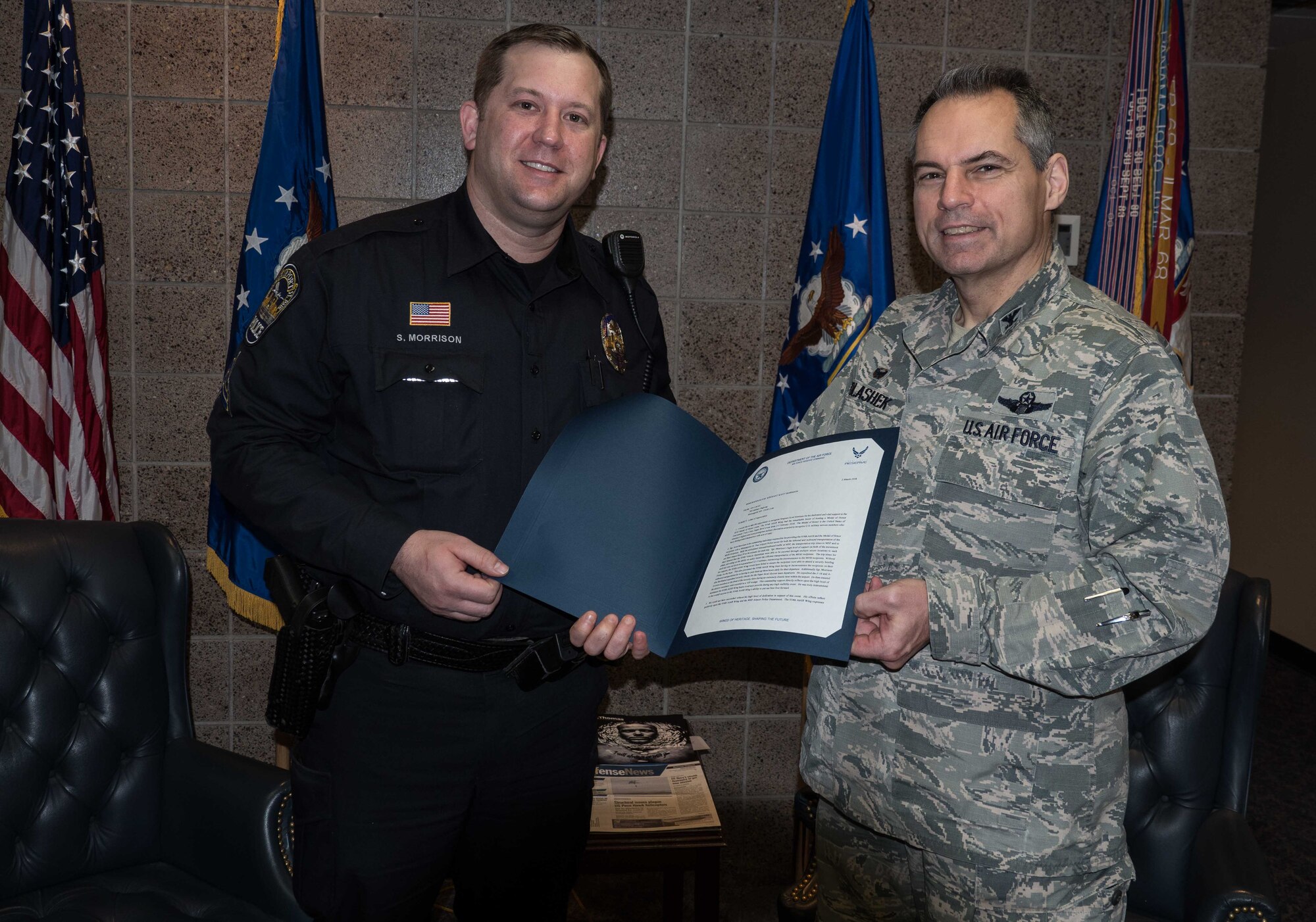 Col. Tony Polashek, 934th Airlift Wing commander, presents Minneapolis airport Police Sgt. Scott Morrison with a commander's coin and letter of appreciation March 6. Morrison was instrumental in assuring safe and efficient travel for Medal of Honor recipients and members of the Air Force Heritage Flight Team to Super Bowl LII and base events. (Air Force Photo/Paul Zadach)