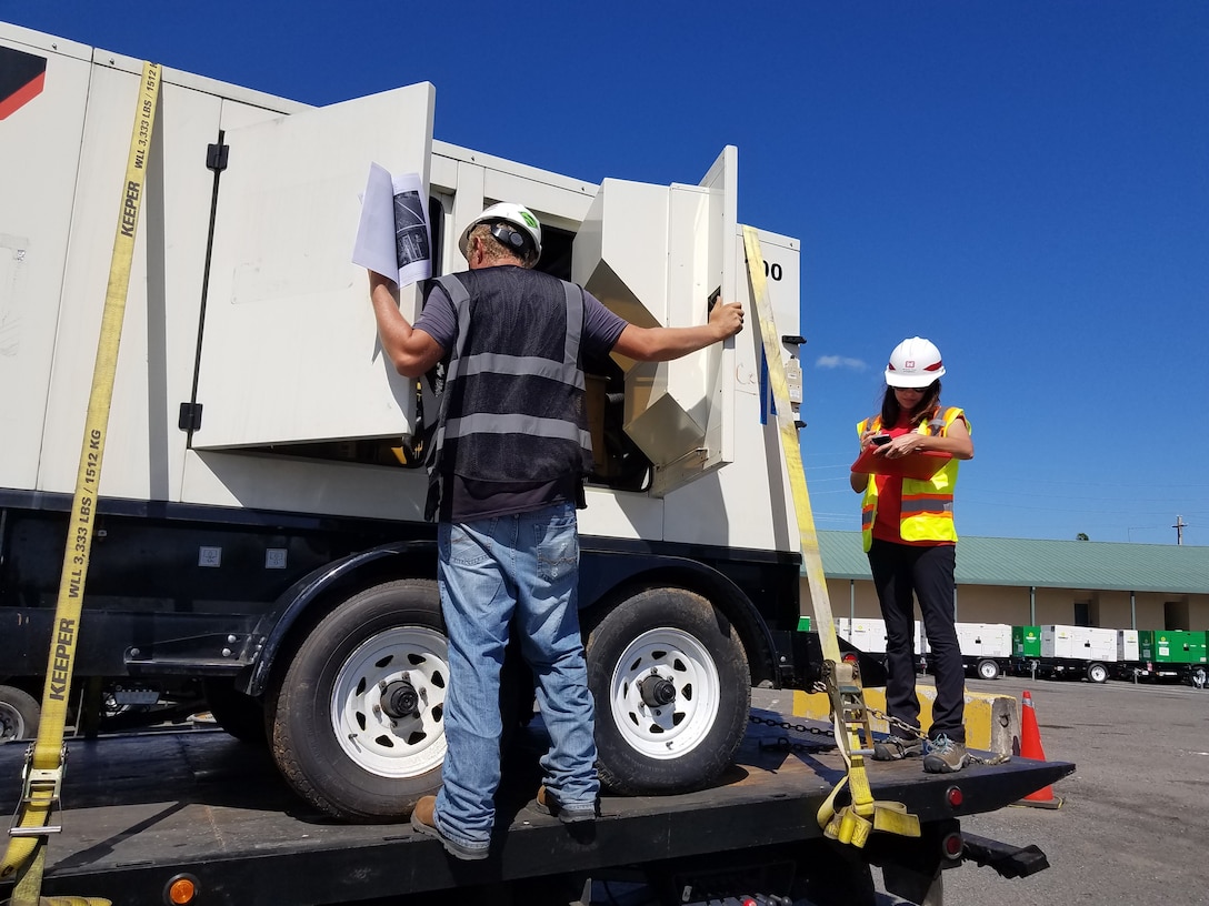 Jessica Power (Logistics Specialist) works with a contractor to verify a generator serial number before it leaves the yard for an installation.