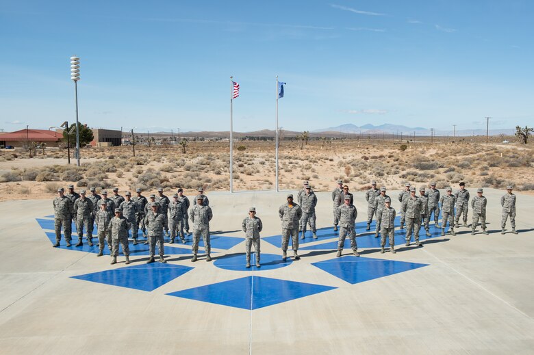 Chief Master Sgt. Ericka E. Kelly, command chief master sgt. for the Air Force Reserve Command (center), poses for a photo with the current Airman Leadership School class on the school's drill pad March 9. (U.S. Air Force photo by Kyle Larson)