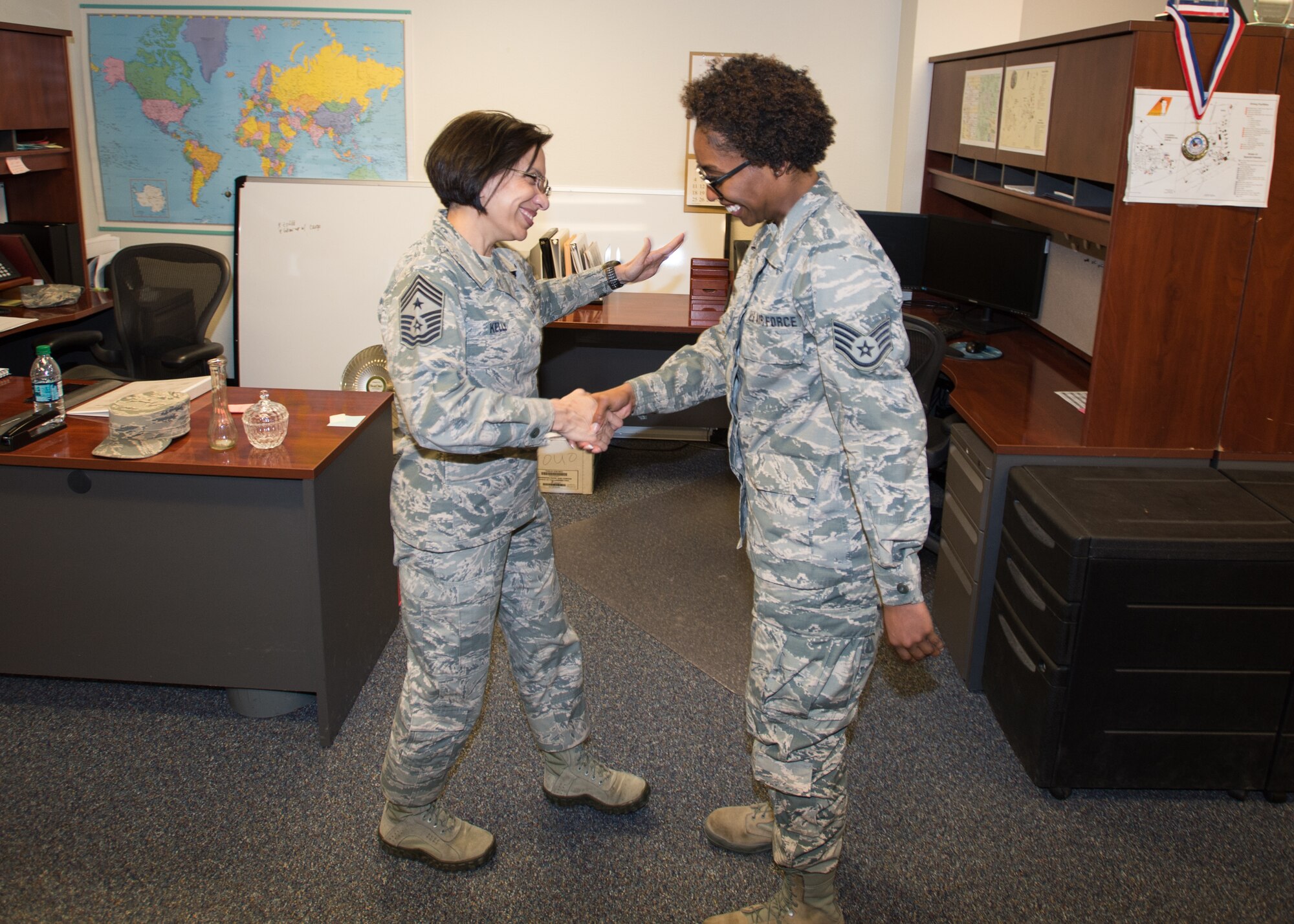 Command Chief Master Sgt. Ericka E. Kelly (left) hands Staff Sgt. Raven Calloway, 412th Logistics Readiness Squadron, an Air Force Reserve Command coin for a job well done March 9. Kelly is the U.S. Air Force Reserve Command’s highest ranking enlisted member. Calloway is an Air Force Reserve Airmen on temporary duty from Dobbins Air Reserve Base, Georgia, assigned to the 412th LRS. (U.S. Air Force photo by John Perry)