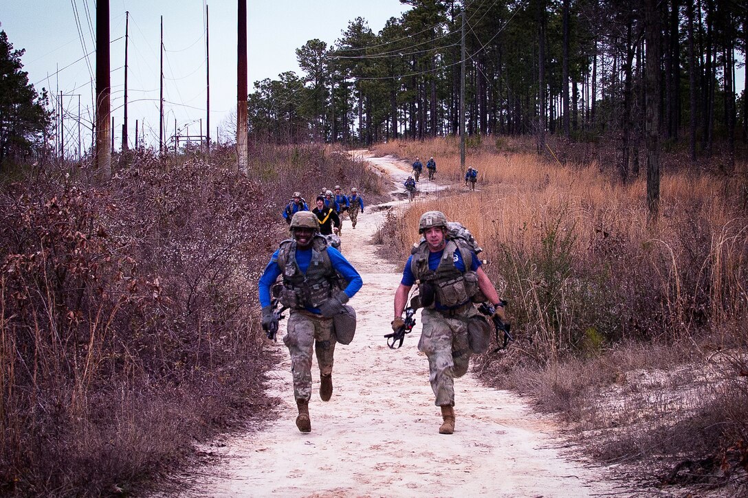 Soldiers run along a trail in a team event.