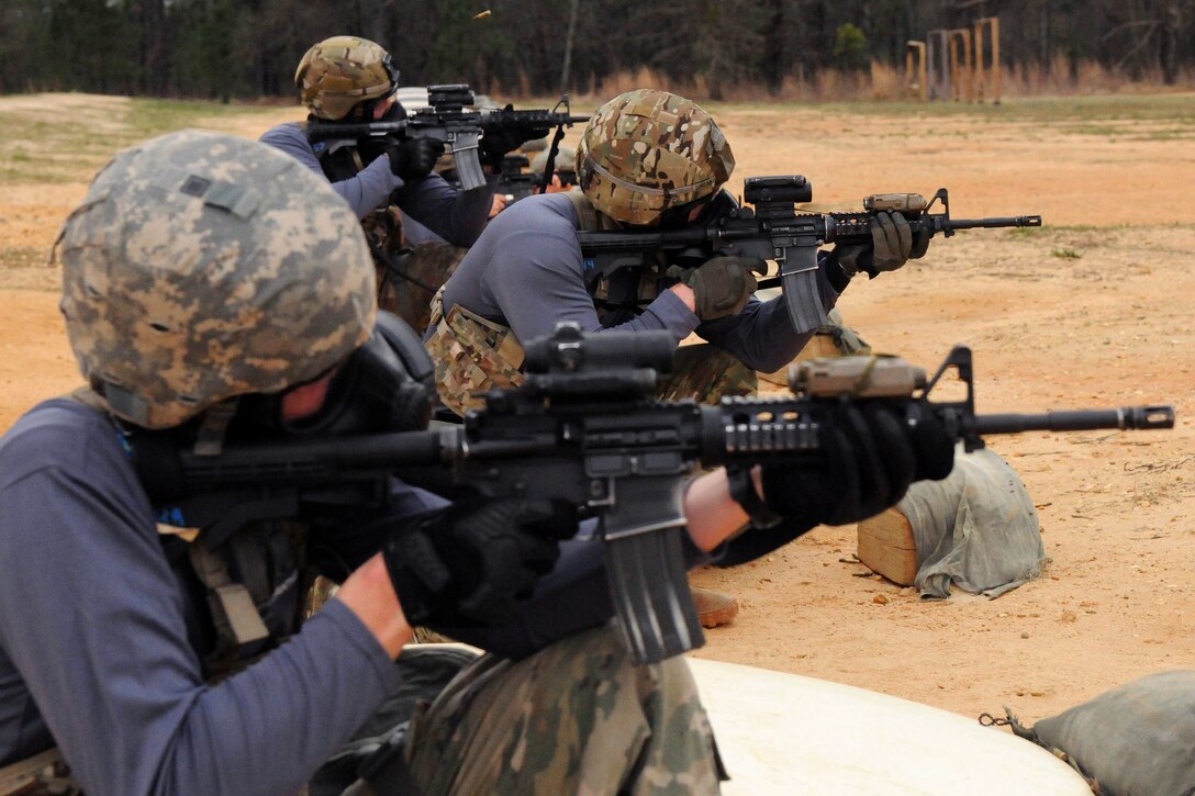 Soldiers fire their weapons during a stress shoot.
