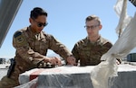 Staff Sgt. Josiah McDonald (left), 455th Expeditionary Logistic Readiness Squadron in-bound cargo NCOIC, and Senior Airman Michael Tomoiaga (right), 455th ELRS traffic management technician, inspect in-bound cargo Mar. 16, 2018 at Bagram Airfield, Afghanistan.