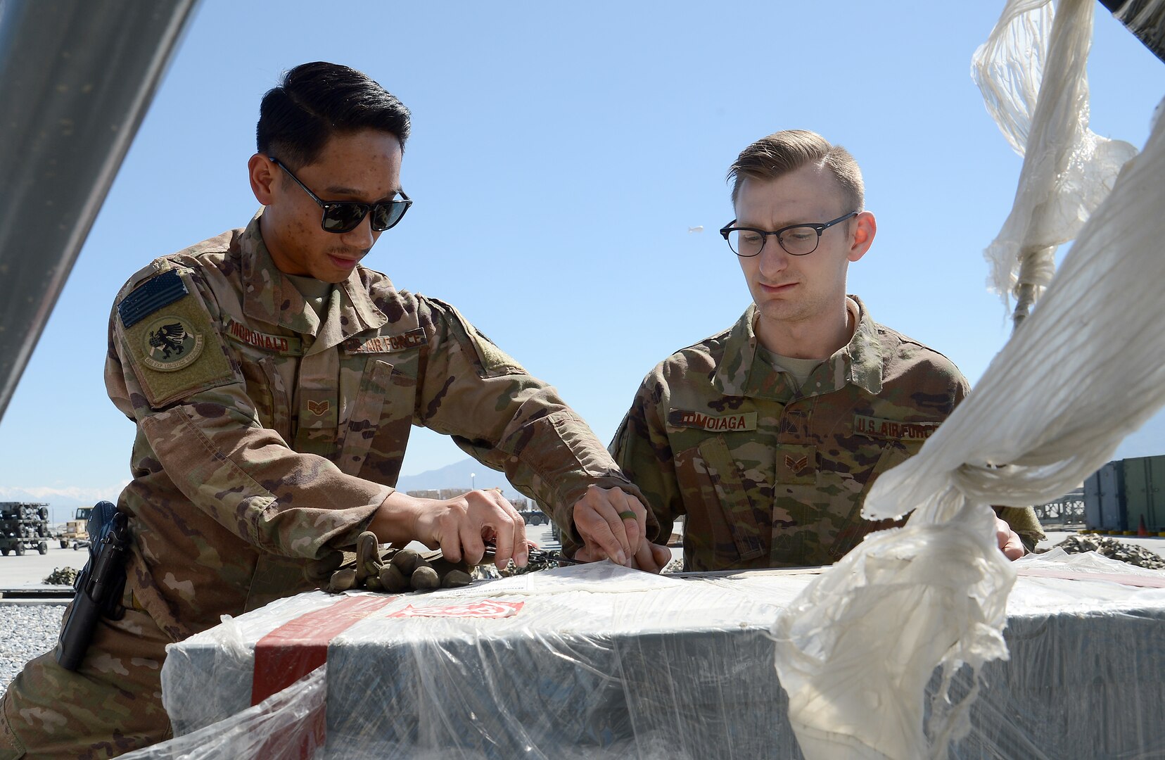 Staff Sgt. Josiah McDonald (left), 455th Expeditionary Logistic Readiness Squadron in-bound cargo NCOIC, and Senior Airman Michael Tomoiaga (right), 455th ELRS traffic management technician, inspect in-bound cargo Mar. 16, 2018 at Bagram Airfield, Afghanistan.