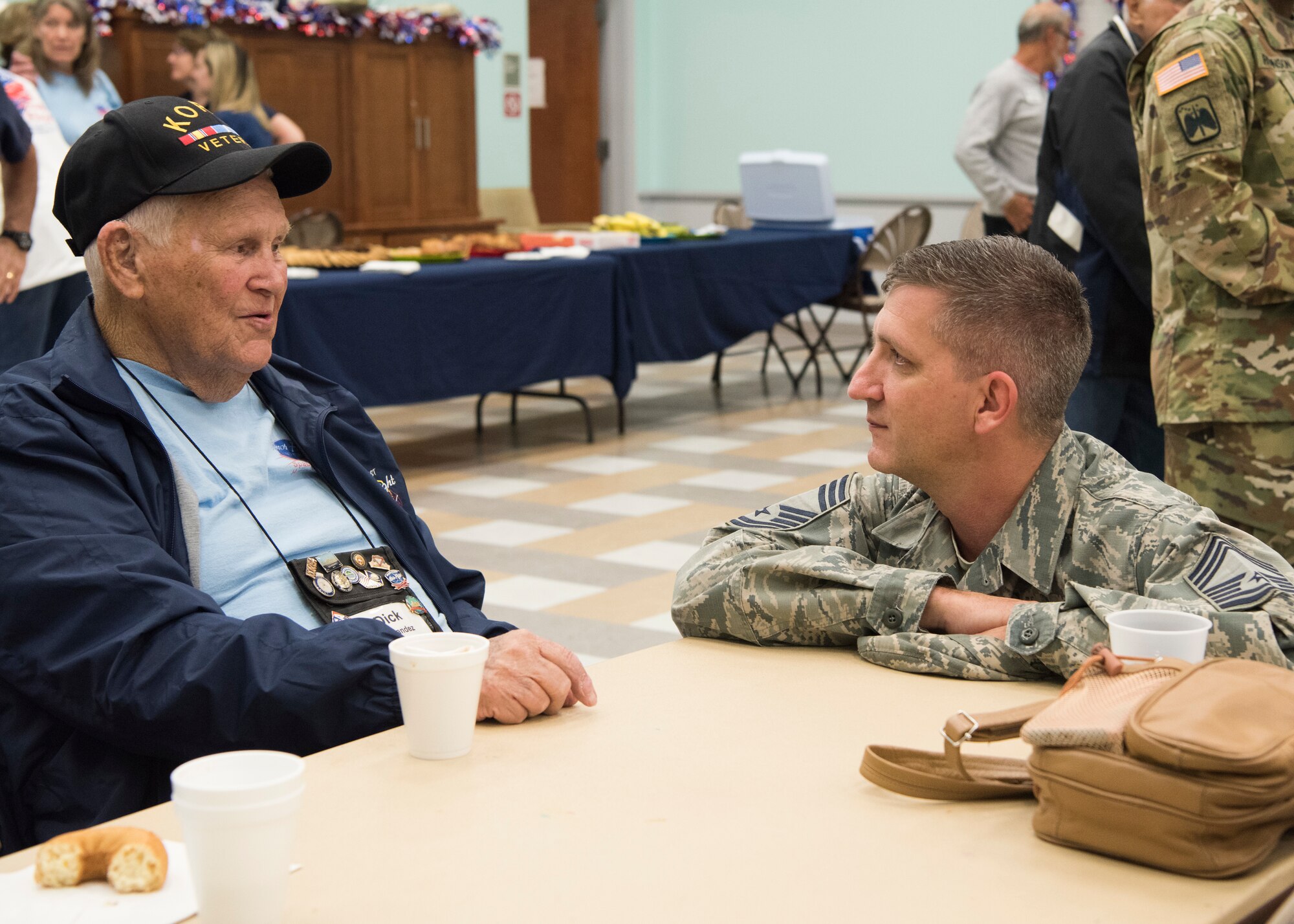 Dick Hernandez, a Korean War veteran, speaks to a Airman, March 17, 2018 at Wickham Park Senior Center, in Melbourne, Fla. Veterans on the Honor Flight see monuments commemorating their sacrifices to our country, such as the Tomb of the Unknown Soldier, and Korean, Vietnam and World War II memorials.