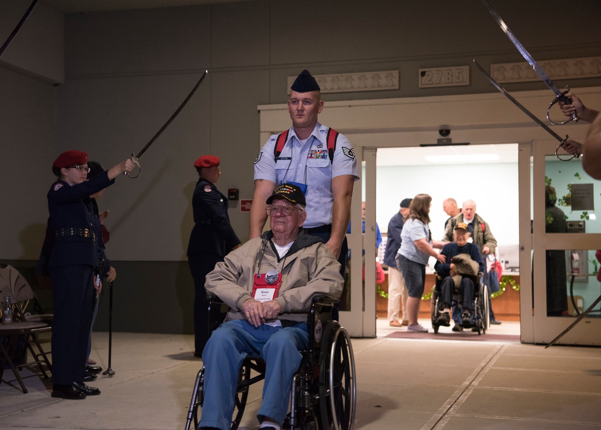 Airmen helps veteran move through a tunnel of sabers, March 17, 2018 at Wickham Park Senior Center in Melbourne, Fla. Honor Flight veterans move through a saber arch before traveling to Washington D.C.