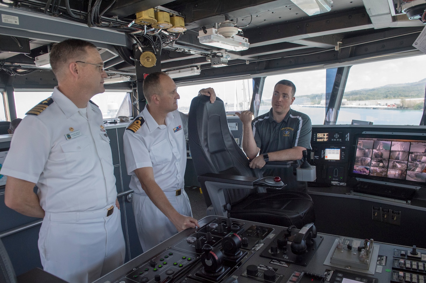 NAVAL BASE GUAM (March 17, 2018) Pacific Partnership 2018 (PP18) Mission Commander, Capt. David Bretz; PP18 Deputy Mission Commander, Her Majesty's Royal Navy Capt. Peter Olive; and Military Sealift Command expeditionary fast transport ship USNS Brunswick (T-EPF 6) ship's master Charles Black, discuss Brunswick's support of PP18 on the ship's bridge. PP18's mission is to work collectively with host and partner nations to enhance regional interoperability and disaster response capabilities, increase stability and security in the region, and foster new and enduring friendships across the Indo-Pacific Region.