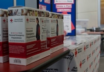 Emergency disaster kits sit on a desk at Misawa Air Base, Japan, March 16, 2018. The kits come equipped with emergency supplies such as a poncho, emergency drinking water, hand warmers and a survival blanket. (U.S. Air Force photo by Airman 1st Class Collette Brooks)