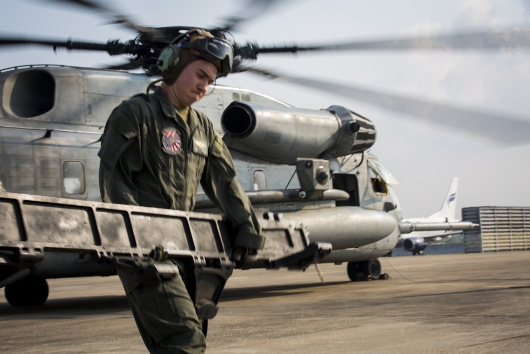 A U.S. Marine with Marine Heavy Helicopter Squadron 466 ‘Wolfpack’ unloads equipment from a CH-53E Super Stallion on the runway at U-Tapao International Airport, Kingdom of Thailand, Feb. 10, 2018. HMH-466 ‘Wolfpack’ arrive to the Kingdom of Thailand to participate in the 37th iteration of Cobra Gold as part of the U.S. Marine Corps Aviation Combat Element. The Super Stallion is assigned to HMH-466, Marine Aircraft Group 16, 3rd Marine Aircraft Wing, currently forward deployed under the unit deployment program with MAG-36, 1st MAW, based out of Okinawa, Japan. Exercise Cobra Gold 2018 is an annual exercise conducted in the Kingdom of Thailand held from Feb. 13-23 with seven full participating nations. (U.S. Marine Corps photo by Cpl. Andy Martinez)