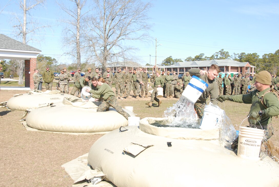 On March 15, 2018 Marine Corps Engineer School (MCES) hosted the annual St. Patrick’s Day Engineer Field Meet to pay homage to St. Patrick, the patron saint for engineers; build camaraderie amongst the engineer and utility communities, and compete for the Engineer Field Meet Trophy. Marines competing in the Water Bucket Relay sprinted across Ellis Field with empty buckets to water bladders, filled the buckets, and then sprinted back across Ellis Field in order to be the first team to fill a 55-gallon trash can.