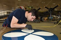(02/22/2018) -- Museum restoration specialist Casey Simmons paints the wheel covers for the Boeing B-17F Memphis Belle. Plans call for the aircraft to be placed on permanent public display in the WWII Gallery here at the National Museum of the U.S. Air Force on May 17, 2018. (U.S. Air Force photo by Ken LaRock)