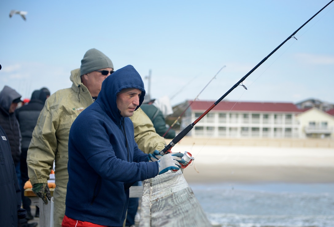 Georgia Army civilian staff member, Zurab Chachanidze, a member of the 2018 Marine Corps Trials Georgian team looks out at the ocean while fishing at Ocean Crest Pier in Oak Island, N.C., March 14, 2018, as part of the USO of North Carolina’s “American Experience Day.” The Marine Corps Trials promotes recovery and rehabilitation through adaptive sport participation and develops camaraderie among recovering service members and veterans. It is as an opportunity for RSMs to demonstrate their achievements and serves as the primary venue to select Marine Corps participants for the DoD Warrior Games.