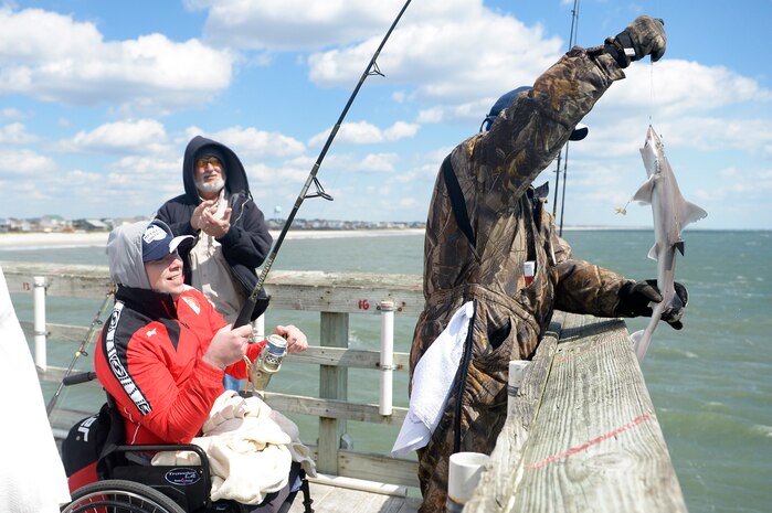 Georgia Army Cpl. Alika Gitolendia, left, a member of the 2018 Marine Corps Trials Georgian team catches a small shark at Ocean Crest Pier in Oak Island, N.C., March 14, 2018, as part of the USO of North Carolina’s “American Experience Day.” The Marine Corps Trials promotes recovery and rehabilitation through adaptive sport participation and develops camaraderie among recovering service members and veterans. It is as an opportunity for RSMs to demonstrate their achievements and serves as the primary venue to select Marine Corps participants for the DoD Warrior Games.