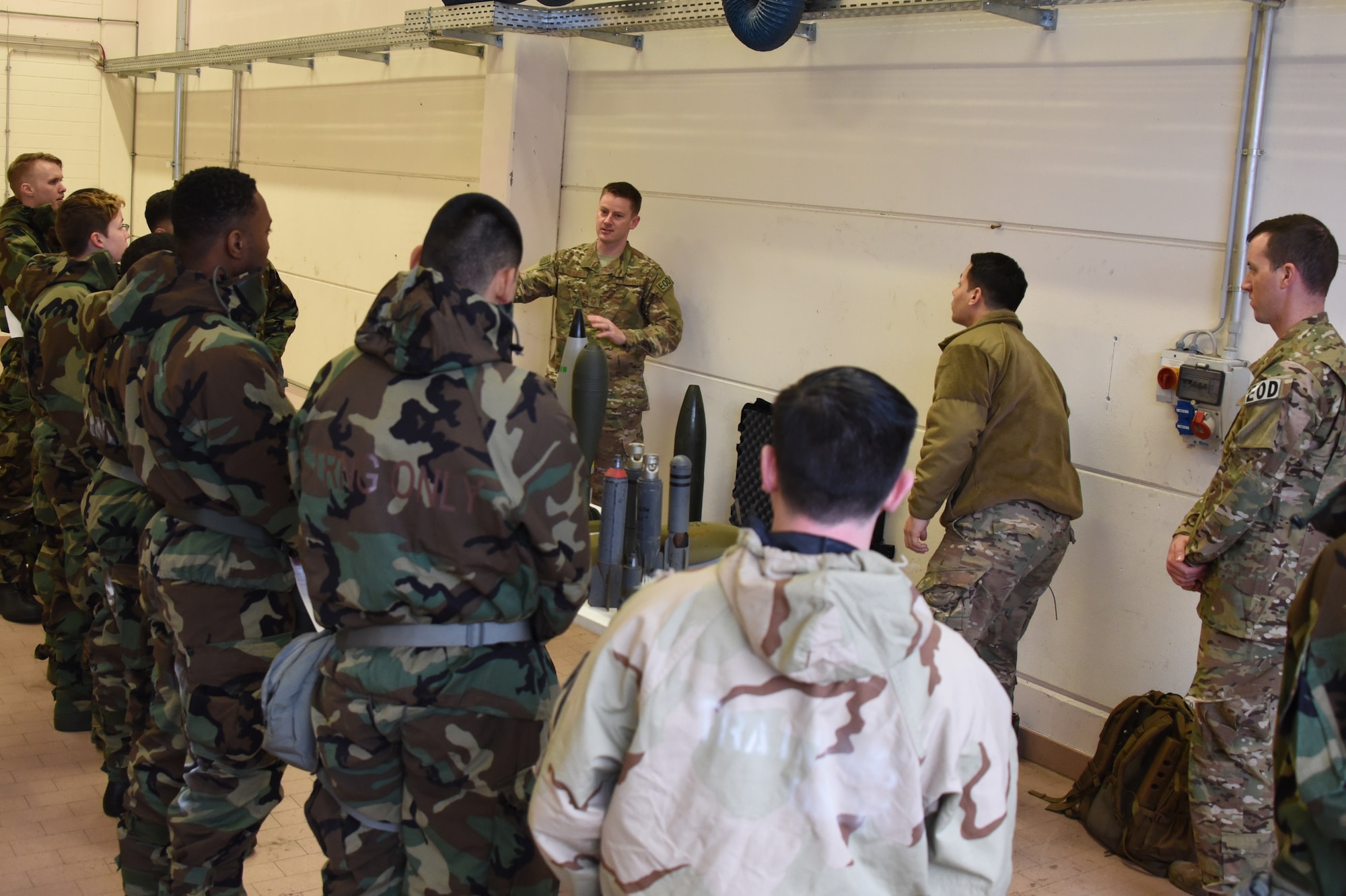 Airmen from the 52nd Civil Engineer Squadron explosive ordnance unit, brief 52nd Fighter Wing Airmen on identifying unexploded ordnance during Ability to Survive and Operate training at Spangdahlem Air Base, Germany, March 8, 2018. ATSO training has proven to be effective in not only improving an Airman’s abilities to perform their duties during less-than-ideal circumstances, but also in preparing the wing populous to respond to CBRN threats or attacks. (U.S. Air Force photo by Senior Airman Dawn M. Weber)