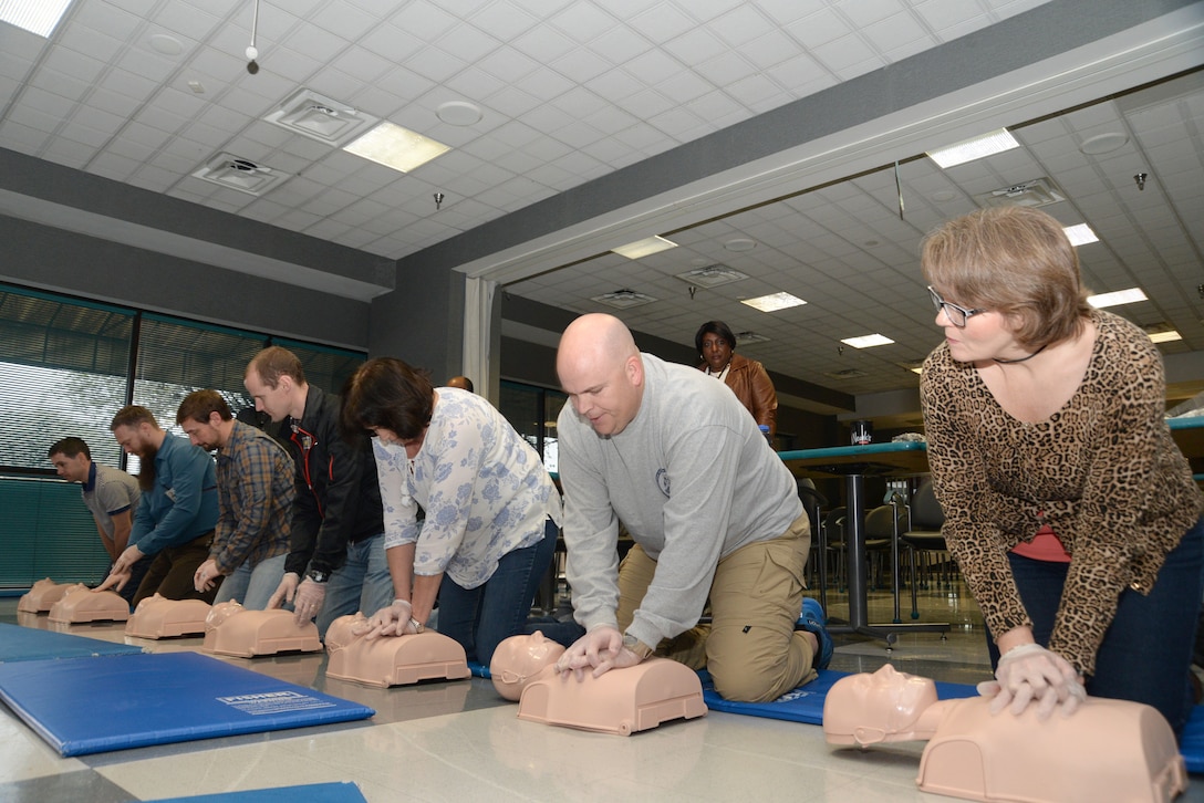 Employees of the U.S. Army Engineering and Support Center, Huntsville, practice chest compressions on medical dummies during a first aid and CPR training and certification session March 1 at the Center. Along with their primary duties, the employees serve as first aid attendants for Huntsville Center and must certify annually.