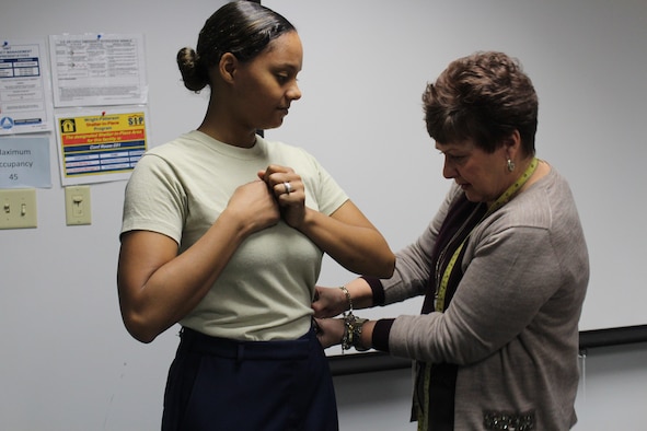 Tracy Roan, Air Force Uniform Office Chief, evaluates the fit of the sample pair of the newly designed female slacks on Staff Sgt. Kierra McCray, executive to the AFLCMC command chief. The sample slacks were designed to reflect modern sizing and style. Improvements to the slacks include lowering the waist line, eliminating darts for a flat front and adding back pockets. (U.S. Air Force Photo/Stacey Geiger)