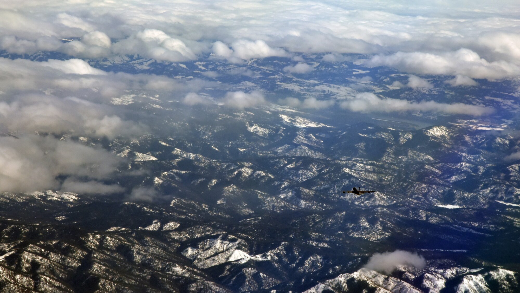 A KC-135 Stratotanker flies over mountains during exercise Titan Fury at Fairchild Air Force Base, Washington, March 9, 2018. The 92nd and 141st Air Refueling Wings teamed up with the 452nd Air Mobility Wing from March Air Reserve Base to focus on their total force partnerships throughout a week of alert-force operations. (U.S. Air Force photo/ Senior Airman Michala Weller)