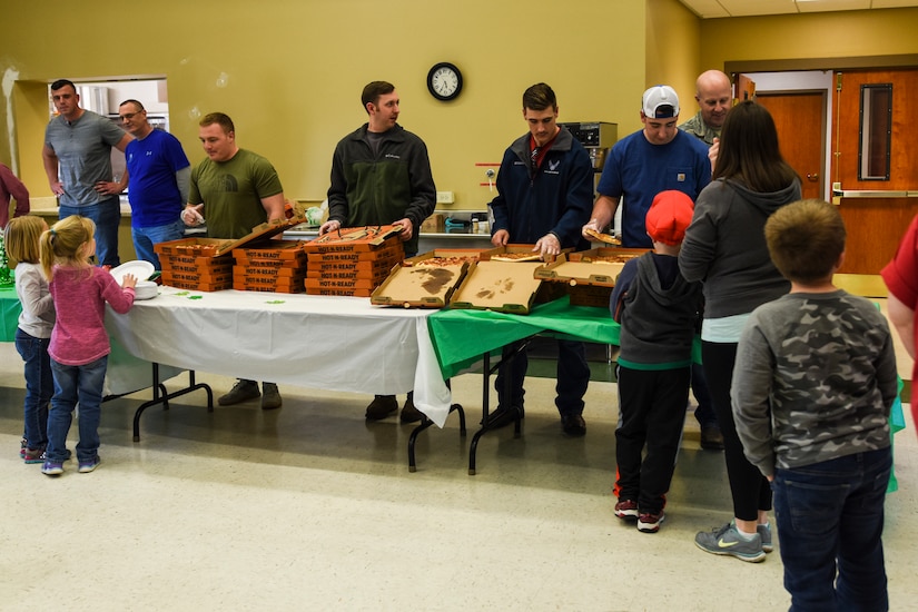 Volunteers from Airman Leadership School class 18-C serve pizza to families March 13, 2018, at Joint Base Charleston, S.C.