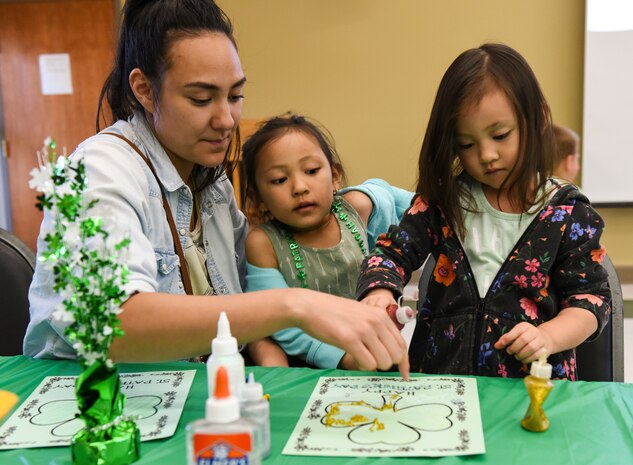 Rachel Gomez, Team Charleston family member, assists daughters Riley, left, and Reagan, right, with arts-and-crafts March 13, 2018, at Joint Base Charleston, S.C.