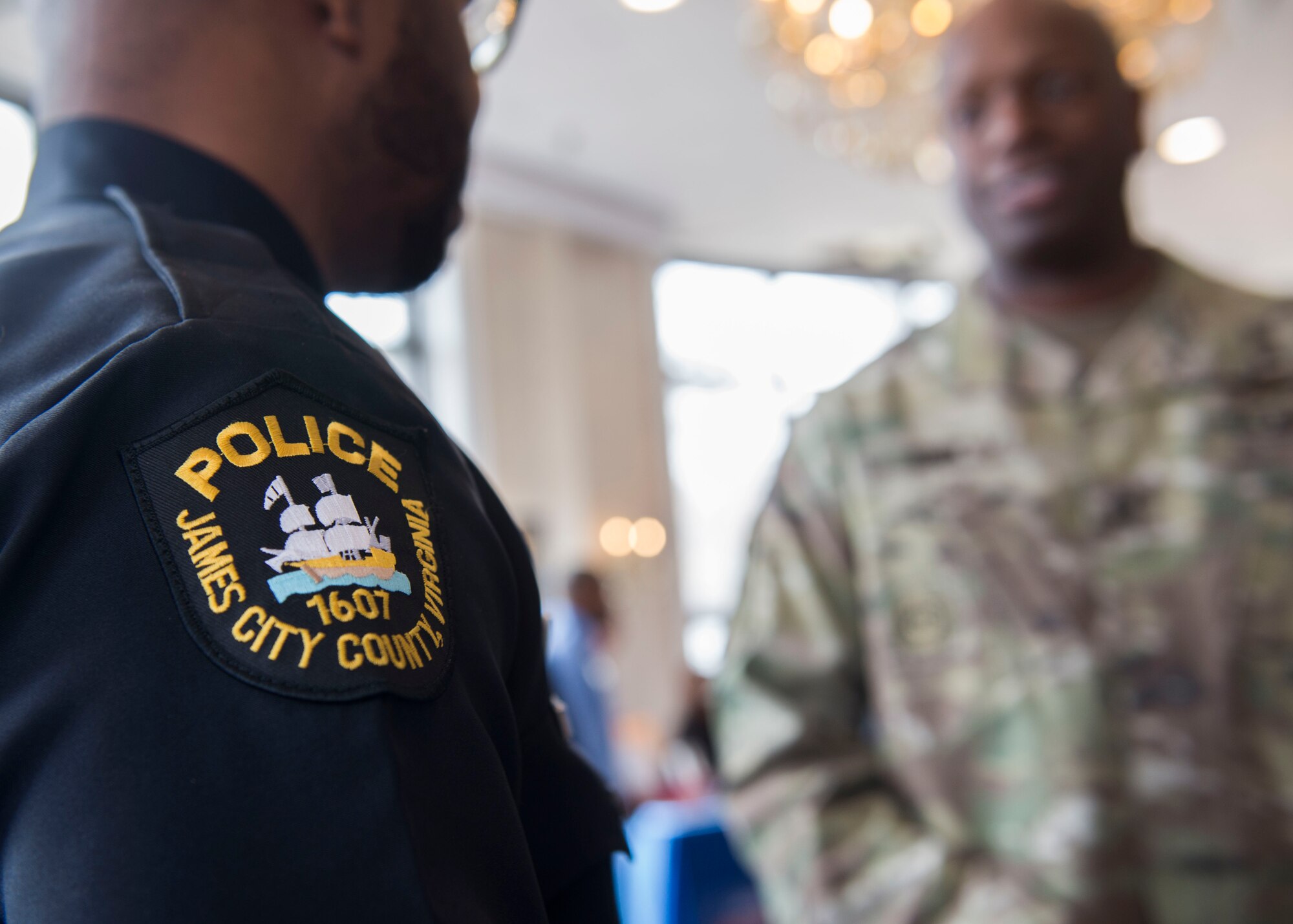U.S. Army Master Sgt. Dedric Knox, 7th Transportation Brigade (Expeditionary) operations NCO in charge, talks to Randy Matthews, James City County Police Department officer, during a job fair at the Fort Eustis Club on Joint Base Langley-Eustis, Virginia, March 15, 2018.