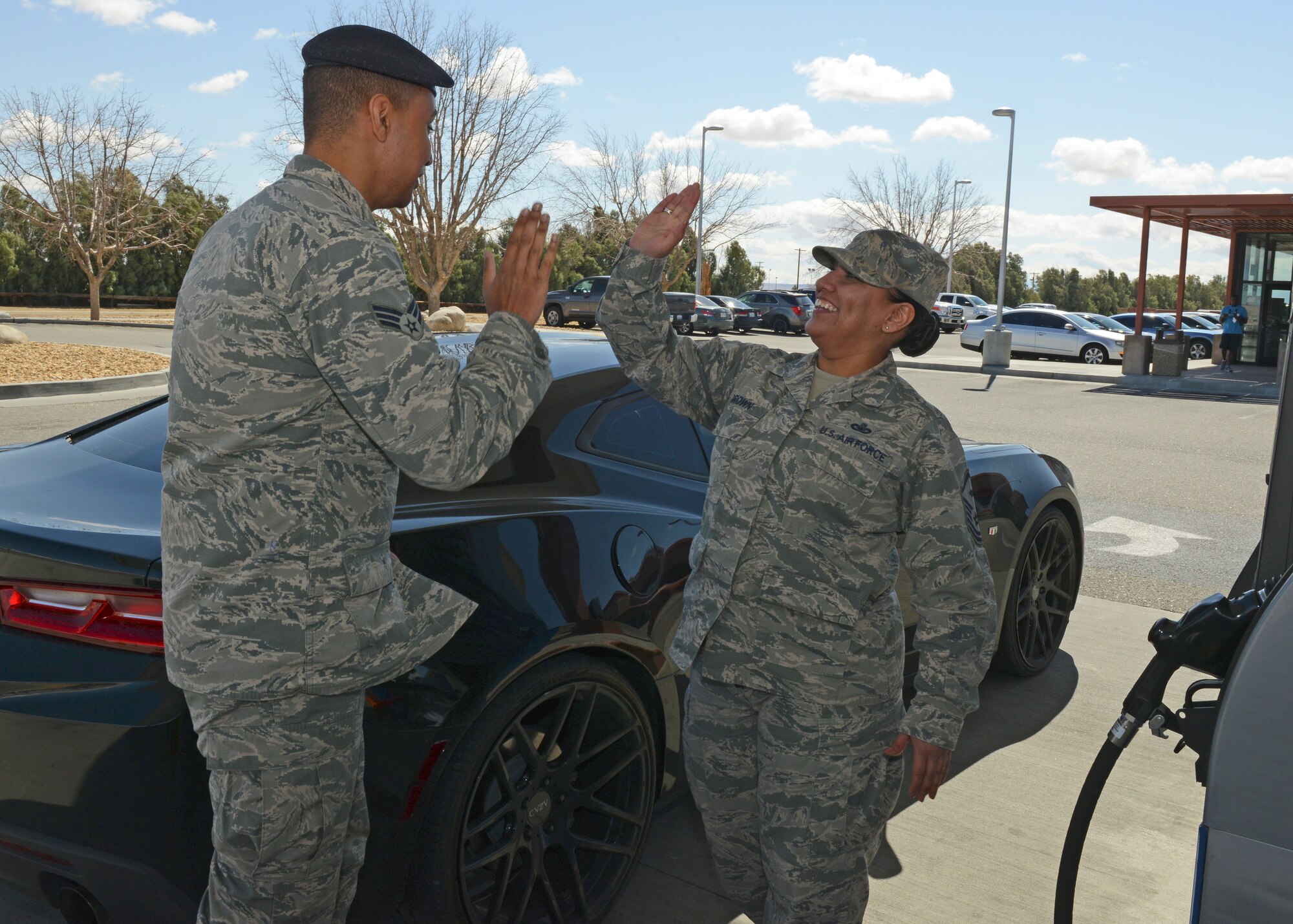 Senior Airman Curtis Bradshaw, 412th Security Forces Squadron, gets a high five from Master Sgt. Venessa Brown, 412th Aircraft Maintenance Squadron first sergeant, at the Express gas station March 14. Brown and her fellow first sergeants conducted a "random-act-of-kindness" event where they paid for and offered to pump gas for junior servicemembers and spouses. (U.S. Air Force photo by Kenji Thuloweit)