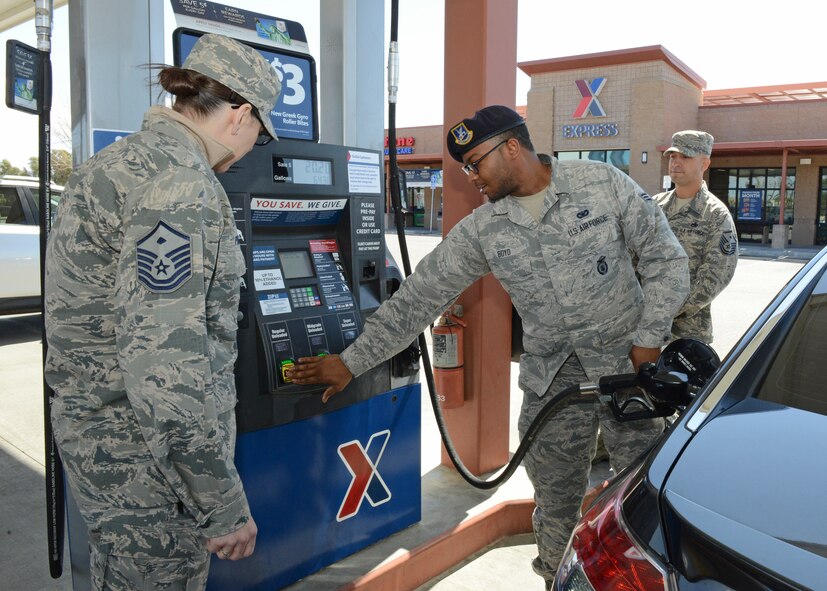 Senior Airman Ryan Boyd, 412th Security Forces Squadron (center), prepares to fuel up his vehicle courtesy of Master Sgt. Brittany Ponder, 31st Test and Evaluation Squadron first sergeant, and Master Sgt. Robert Forbes, 412th Maintenance Group, at the Express gas station March 14. The Edwards First Sergeants Council conducted a "random-act-of-kindness" event where they paid for and offered to pump gas for junior servicemembers and spouses. (U.S. Air Force photo by Kenji Thuloweit)