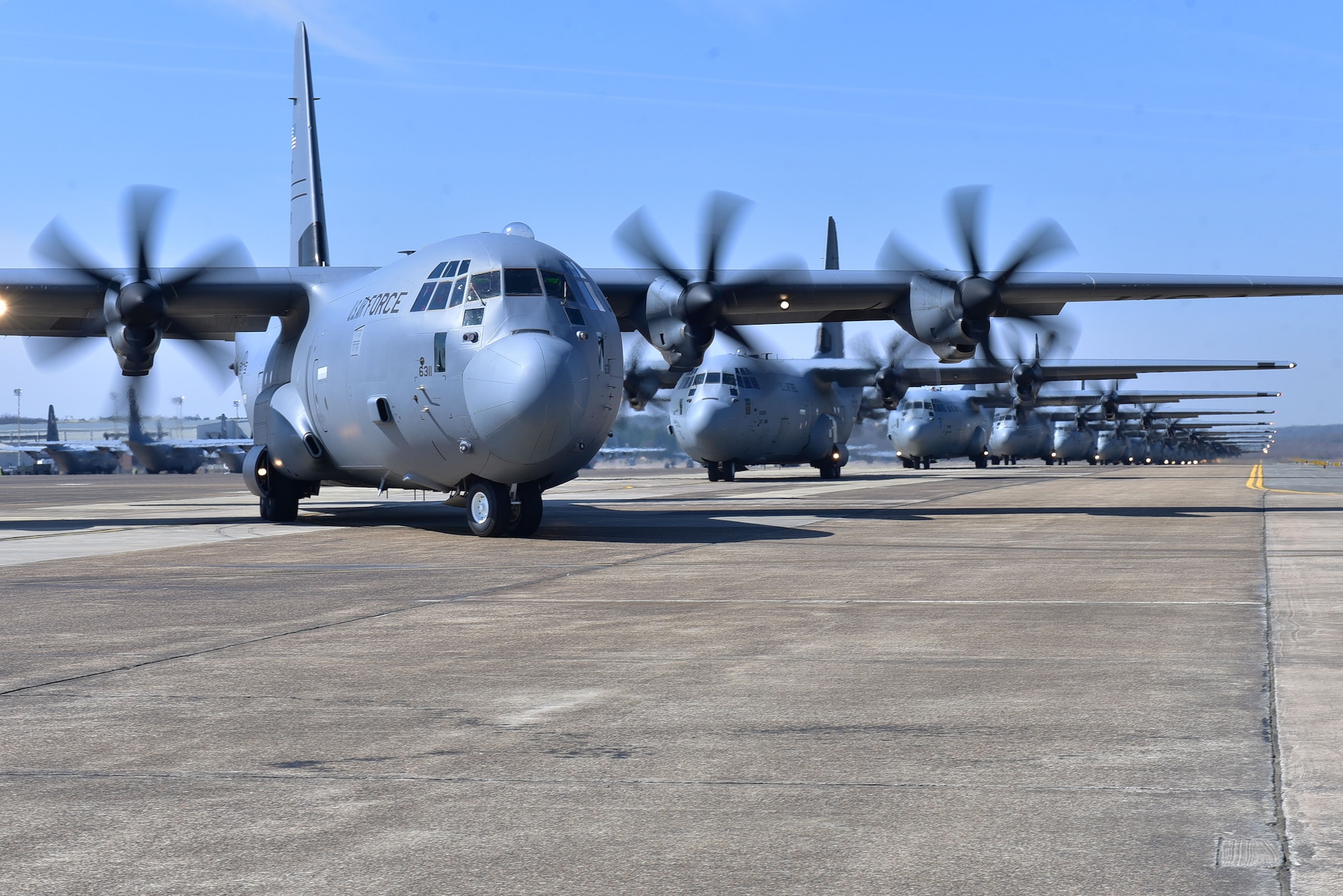 Nineteen C-130s taxi and prepare for takeoff.