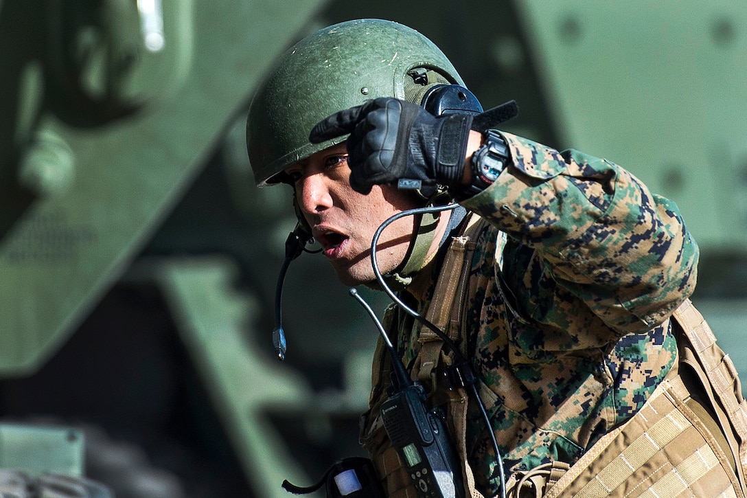 A Marine uses hand signals.
