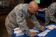 Chief Master Sgt. Elvin Young, 374th Airlift Wing command chief, fills out a pledge form for the Air Force Assistance Fund at Yokota Air Base, Japan, Mar. 20, 2018.