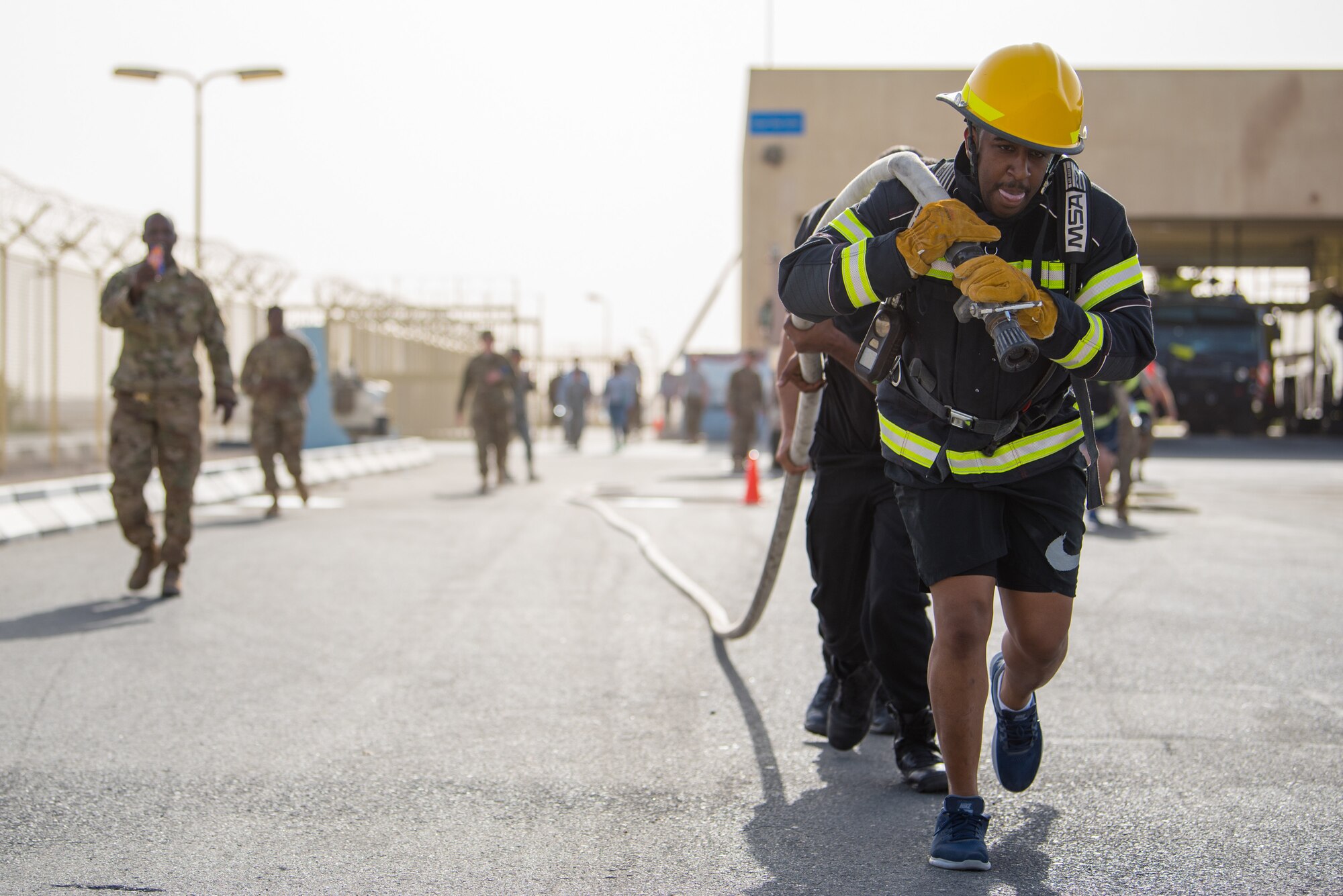 Members of the 379th Air Expeditionary Wing and Qatar Emiri Air Force participate in a firefighter challenge exercise at Al Udeid Air Base, Qatar, March 8, 2018. The a exercise, a strenuous course designed to test physical fitness and fire response capabilities, was organized by firefighters from the 379th ECES and Qatar Emiri Air Force. (U.S. Air Force photo by Staff Sgt. Joshua Horton)